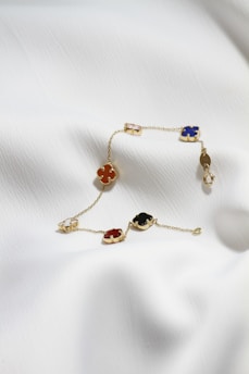 a gold bracelet with four different colored stones