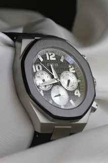 a close up of a watch on a white cloth