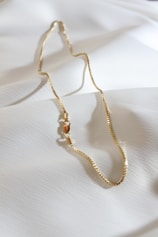 a close up of a necklace on a white sheet