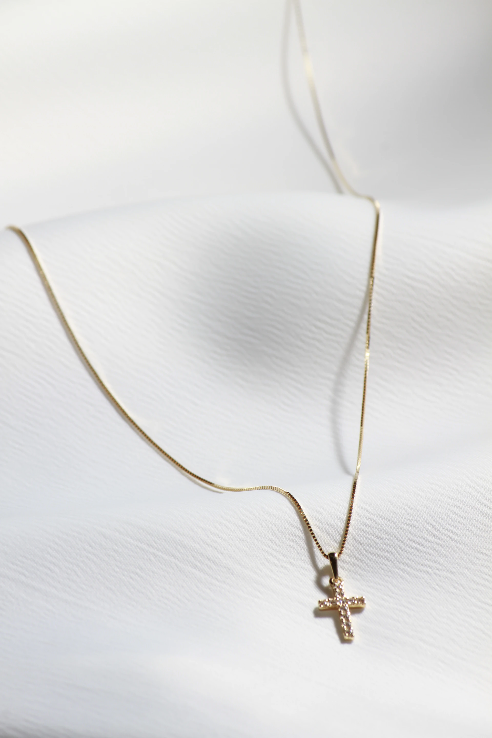 a cross necklace on a white shirt