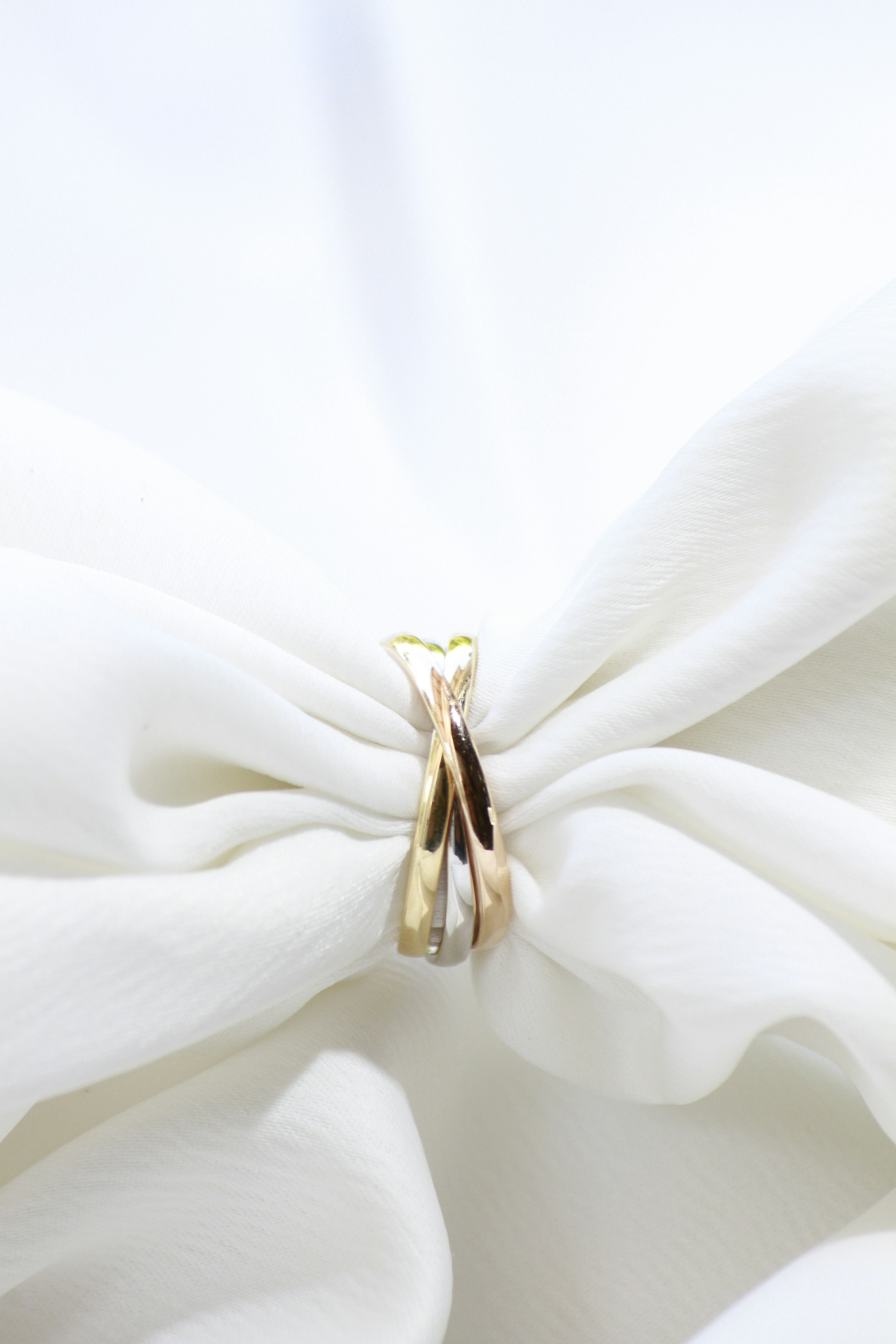 a pair of gold rings sitting on top of a white cloth