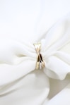 a close up of a white cloth with a gold ring on it