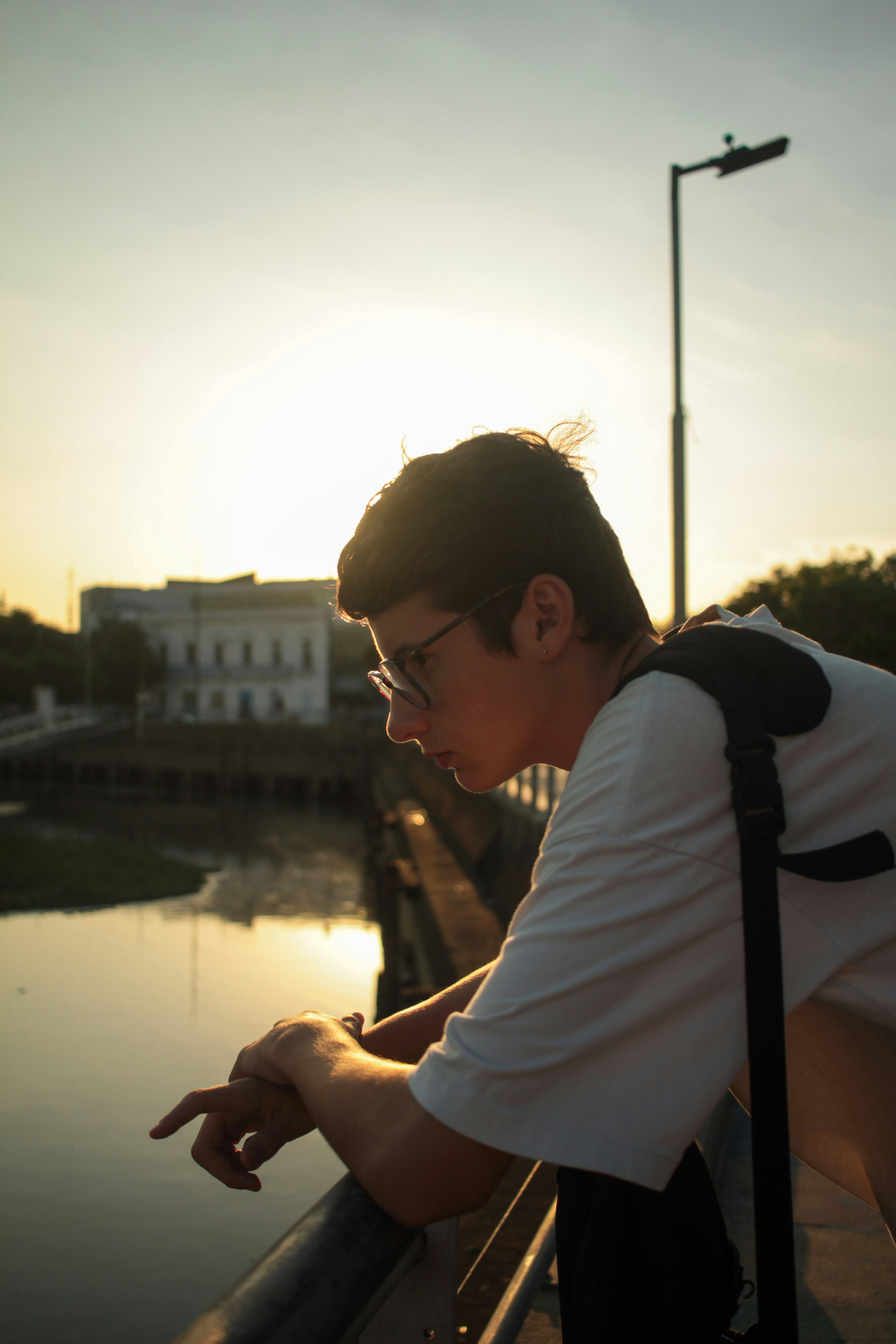 手すりにもたれかかって水面を眺める男