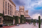 a group of people standing outside of a castle like building