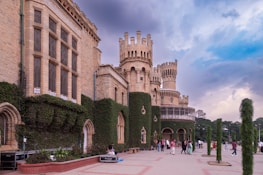a group of people standing outside of a castle like building