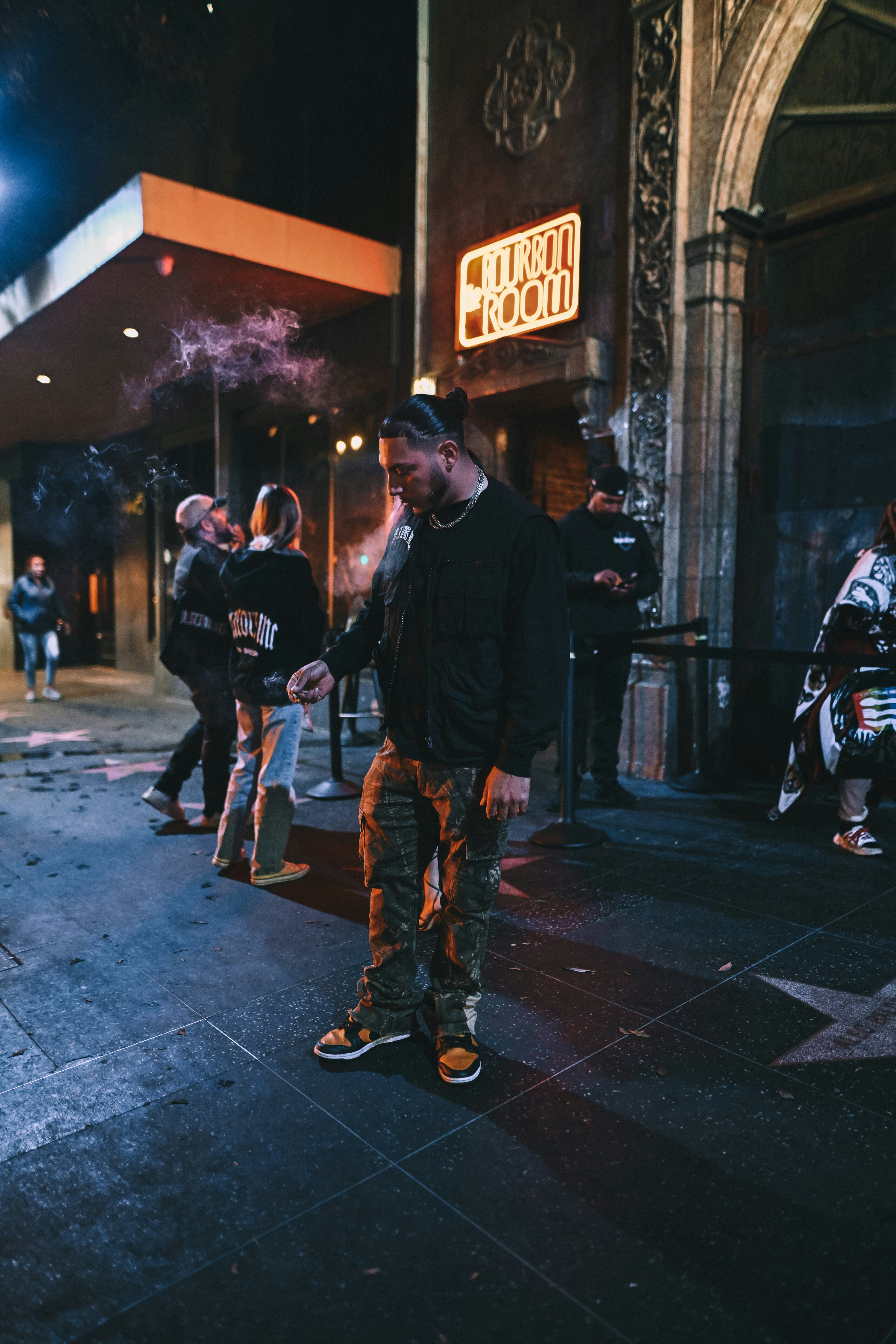 a man standing on a sidewalk in front of a building