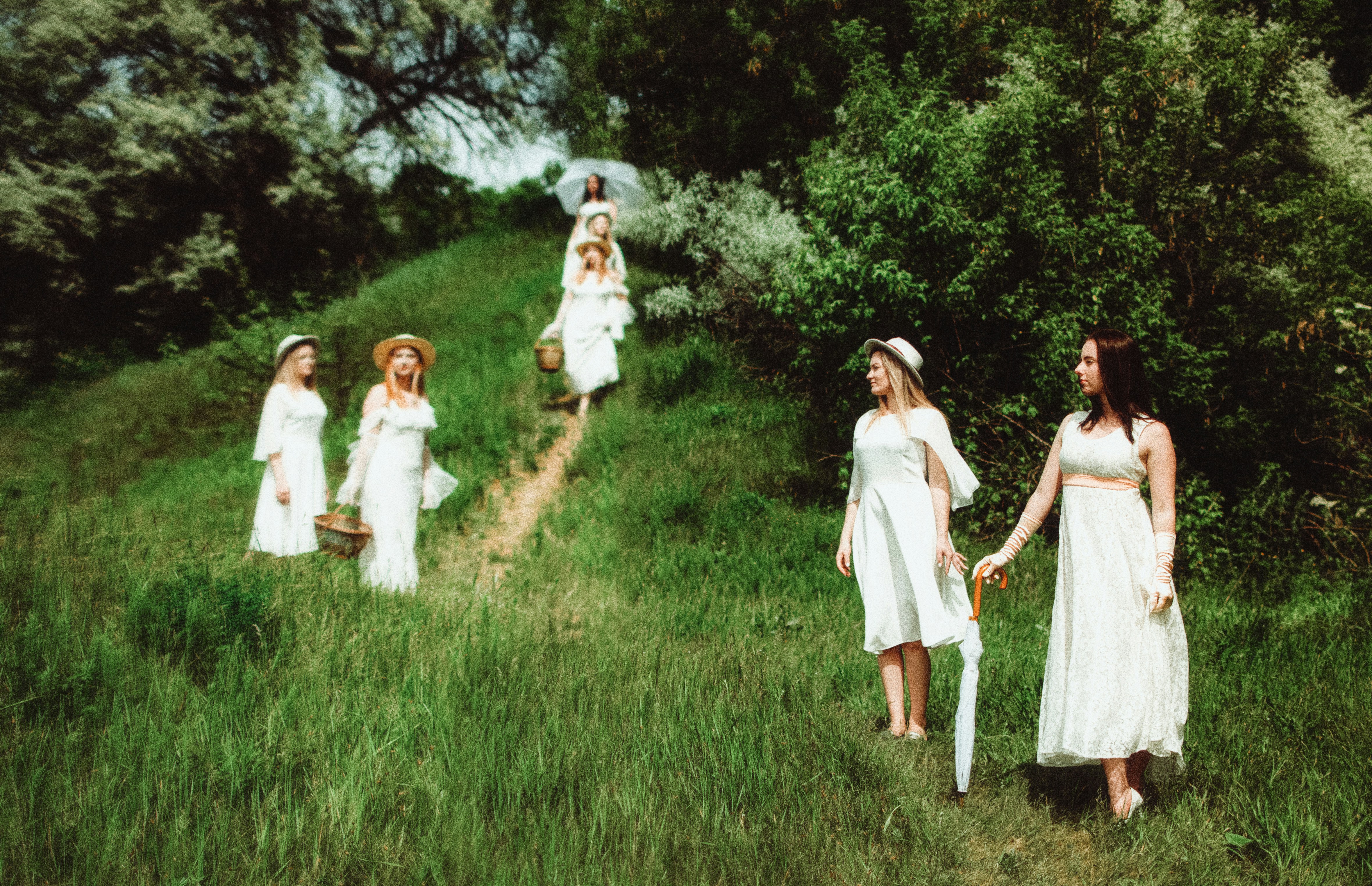 a group of women walking down a lush green hillside