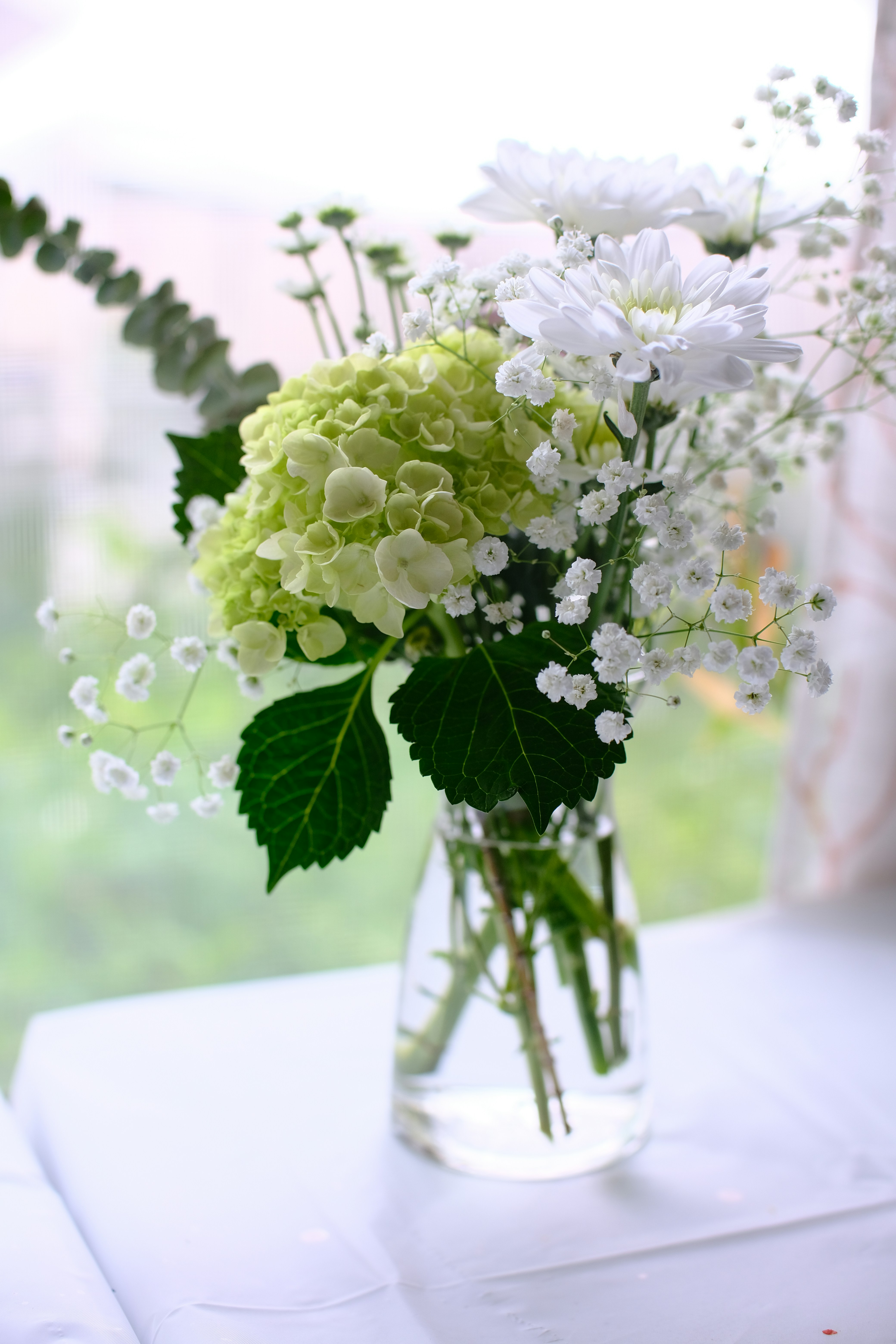 a vase filled with white and green flowers