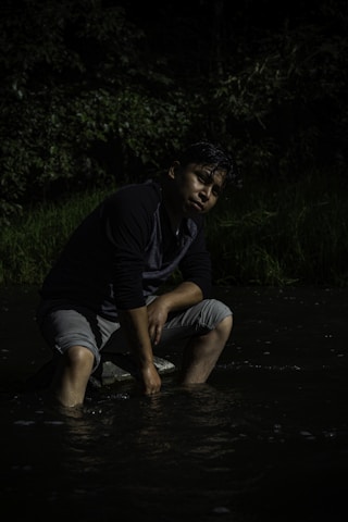 a man kneeling down in the water with a frisbee