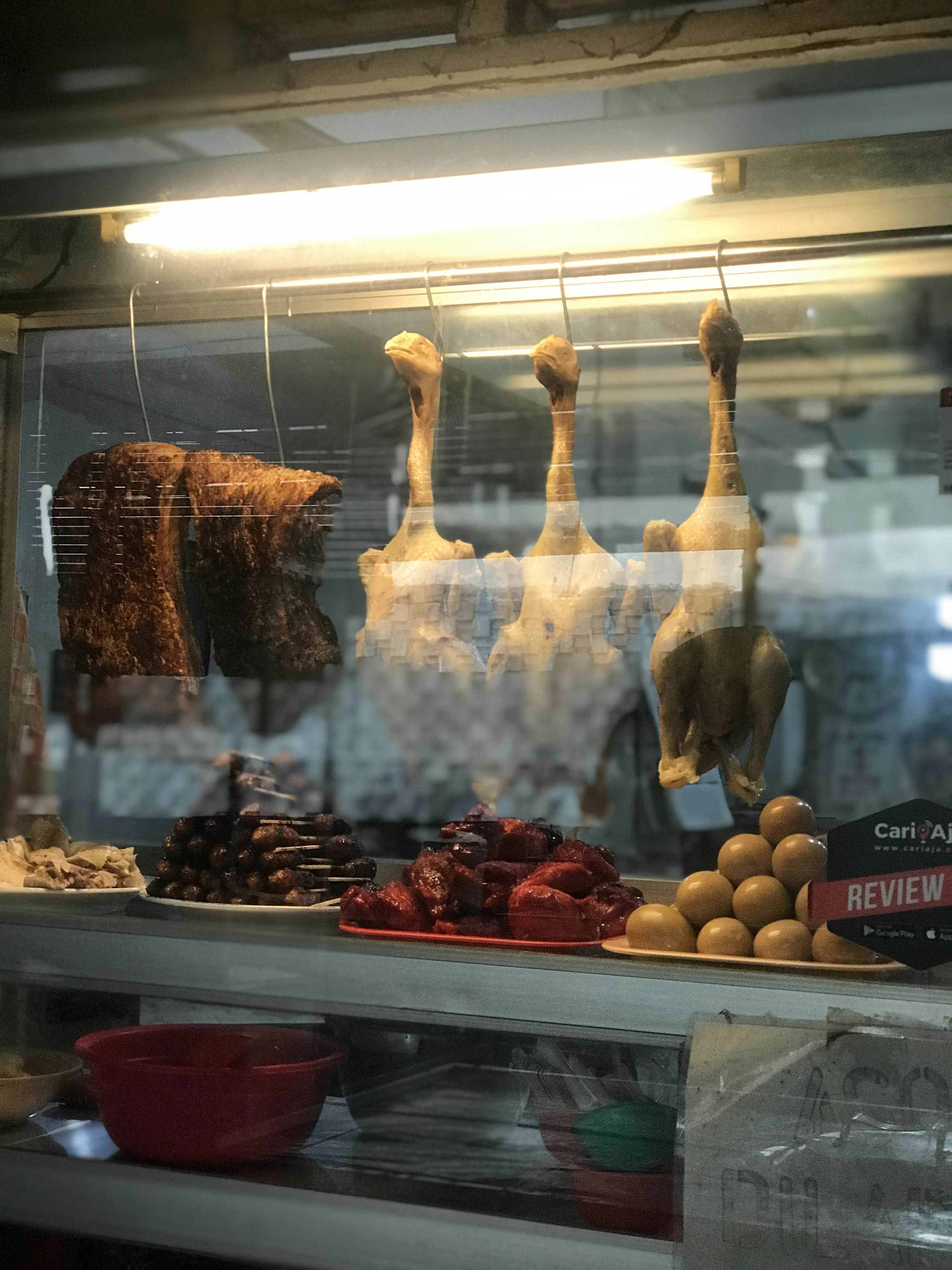 a bunch of meat hanging in a window