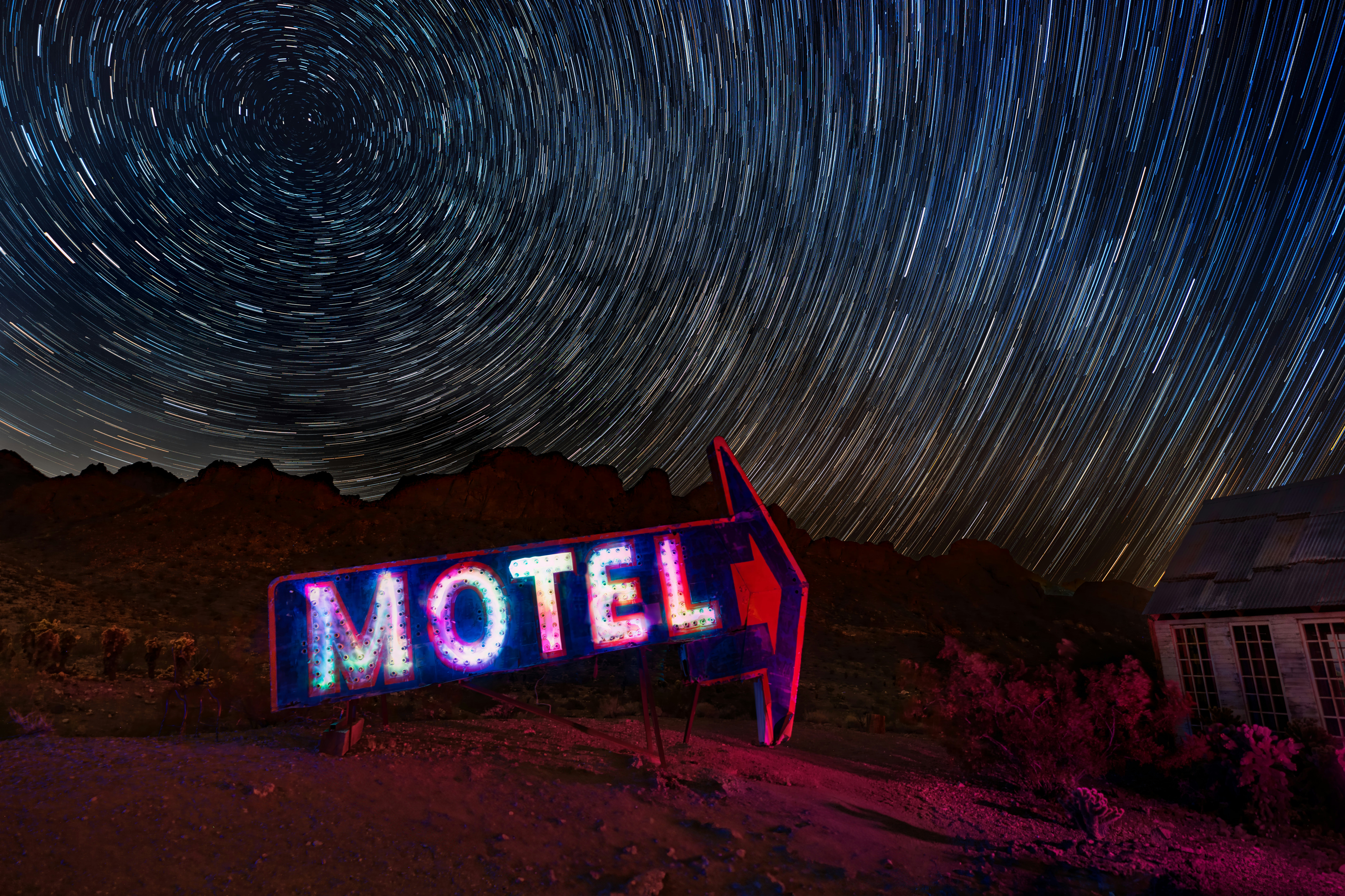 a motel sign with a star trail in the background