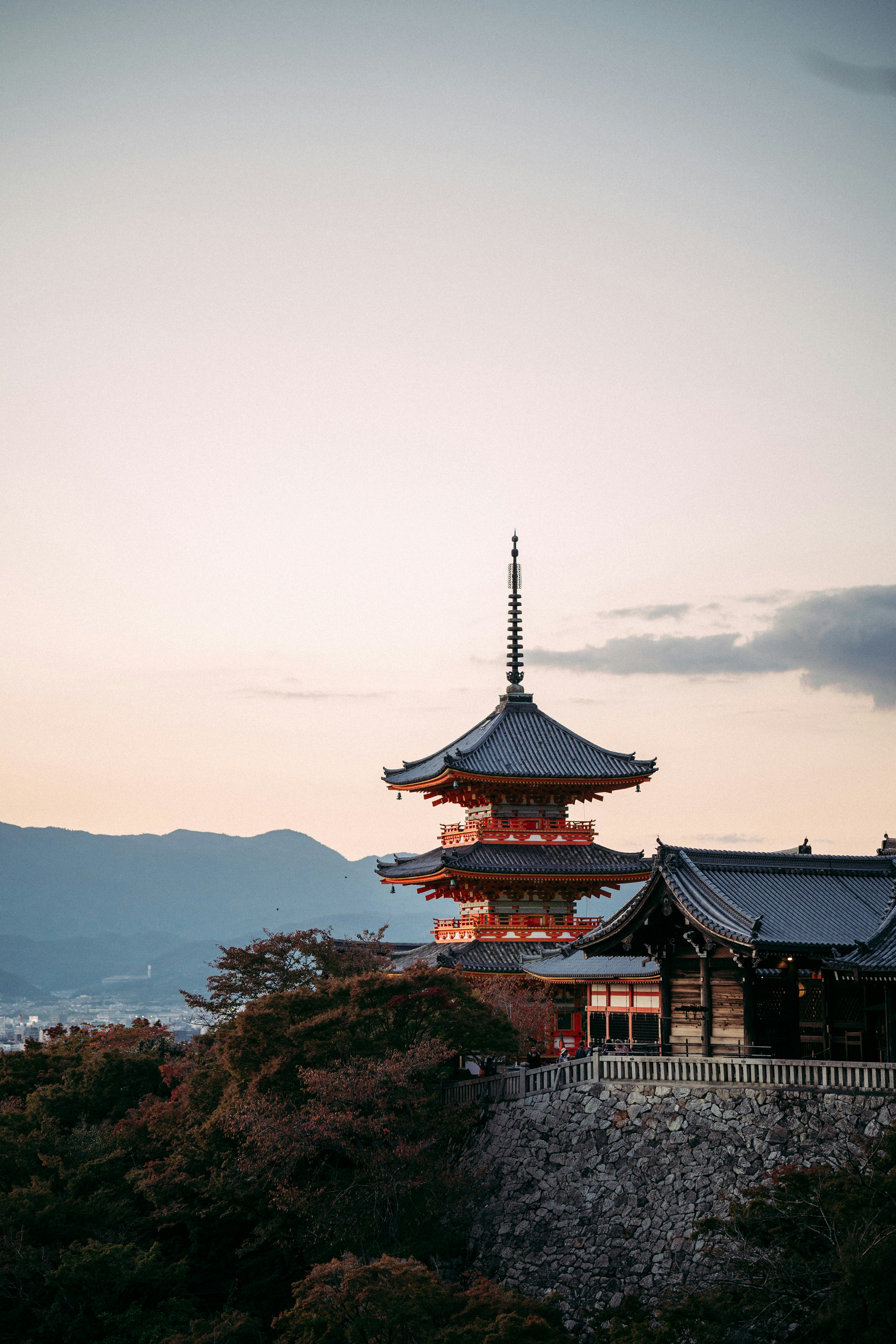 a tall building sitting on top of a lush green hillside