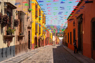 a cobblestone street lined with colorful flags