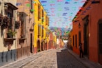 a cobblestone street lined with colorful flags