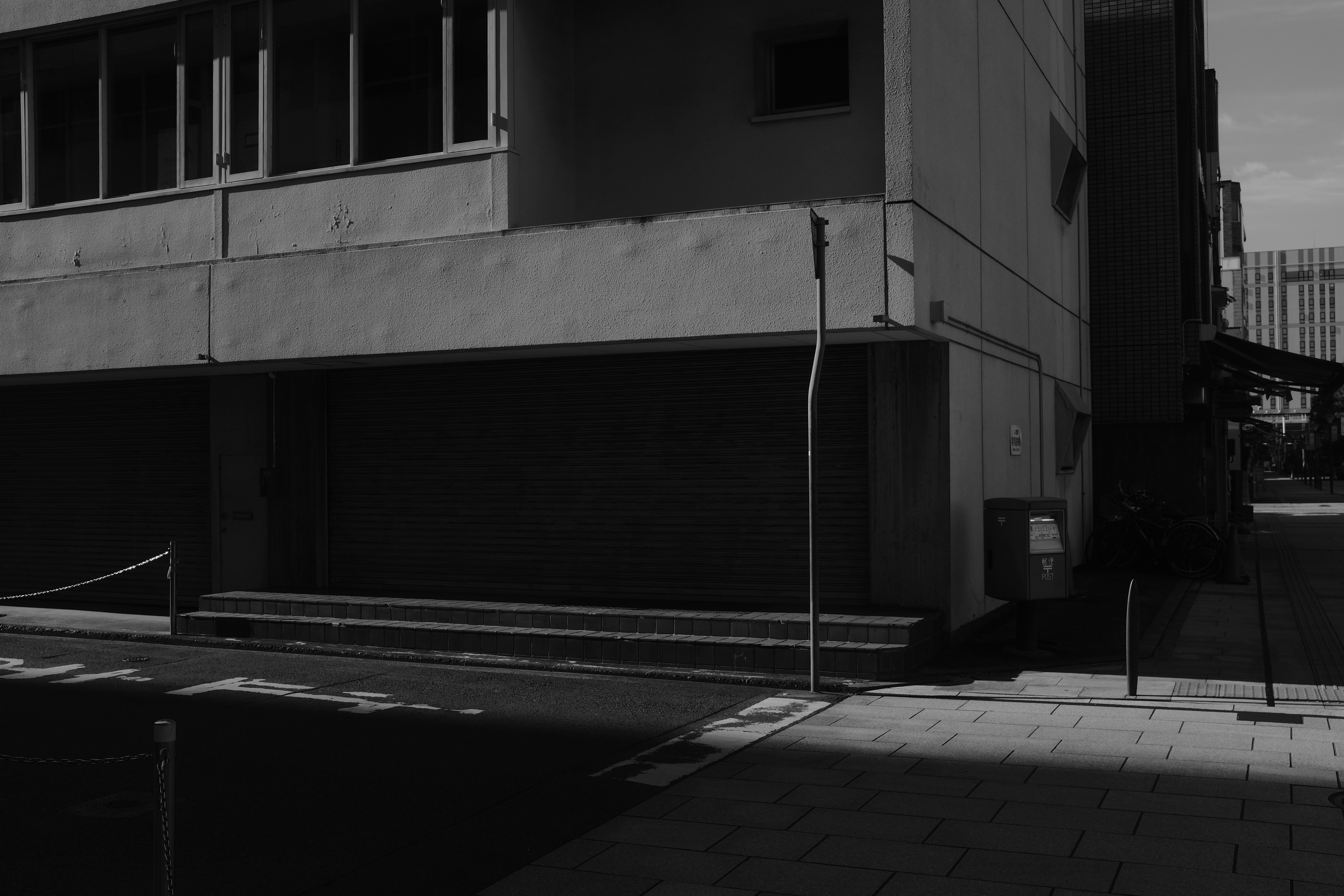 a black and white photo of a street corner