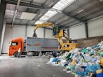 a large truck with a load of trash in a warehouse