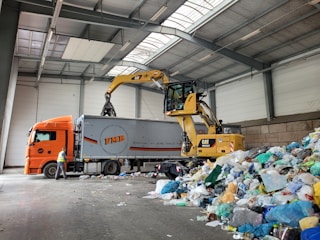 a large truck with a load of trash in a warehouse