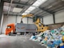 a large truck with a load of trash in a warehouse