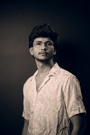 a man with glasses is posing for a picture