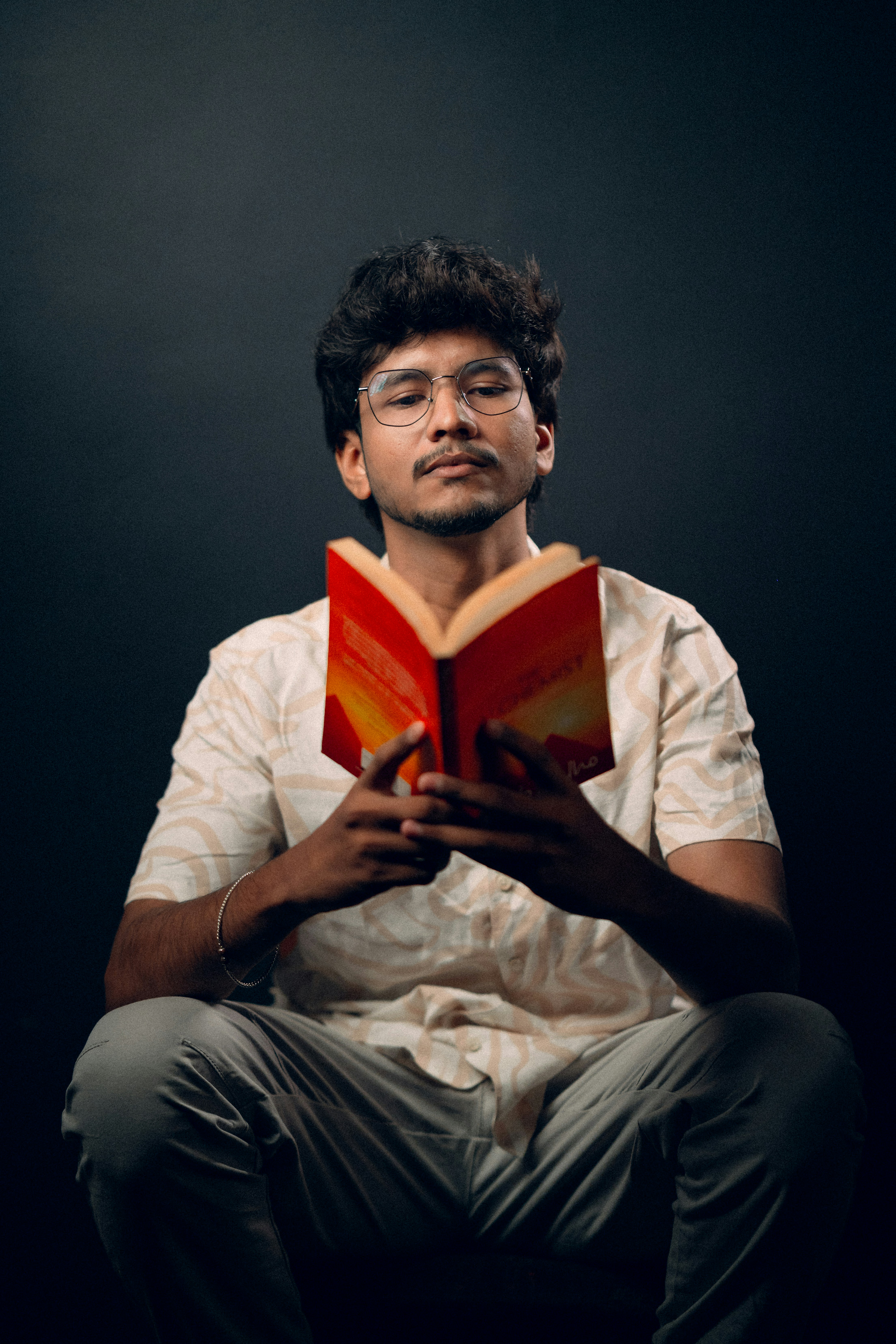 a man is sitting down reading a book