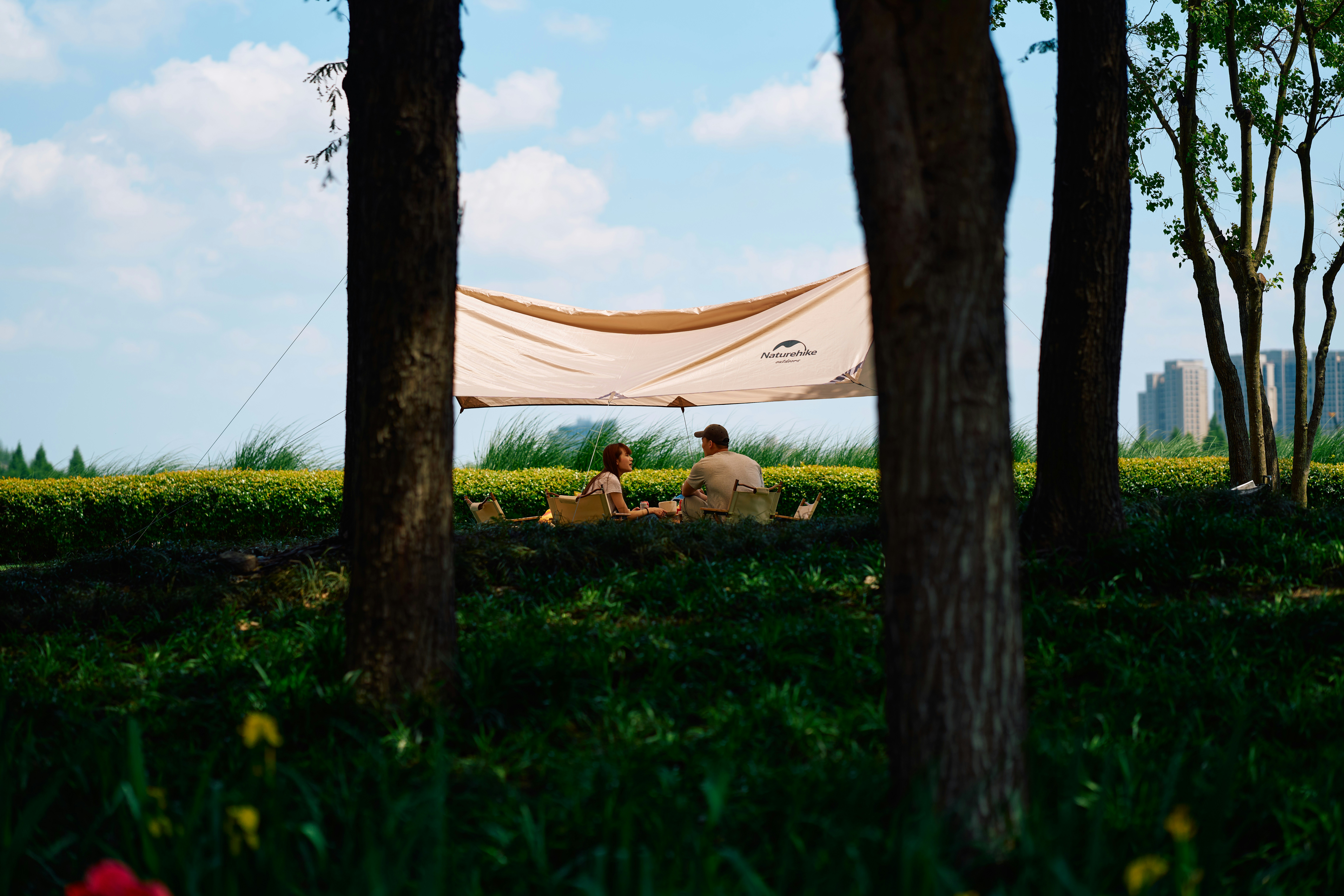 ein paar Leute, die unter einem Zelt auf einem Feld sitzen