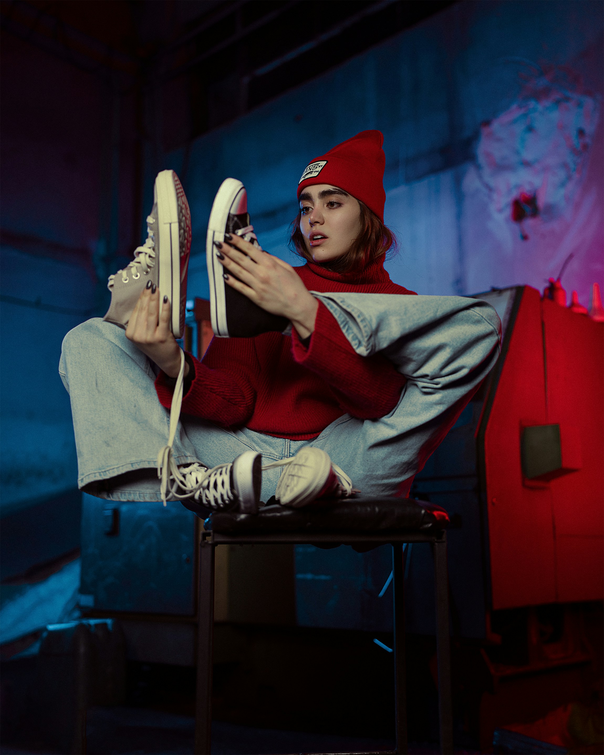 a woman sitting on a chair holding a pair of shoes