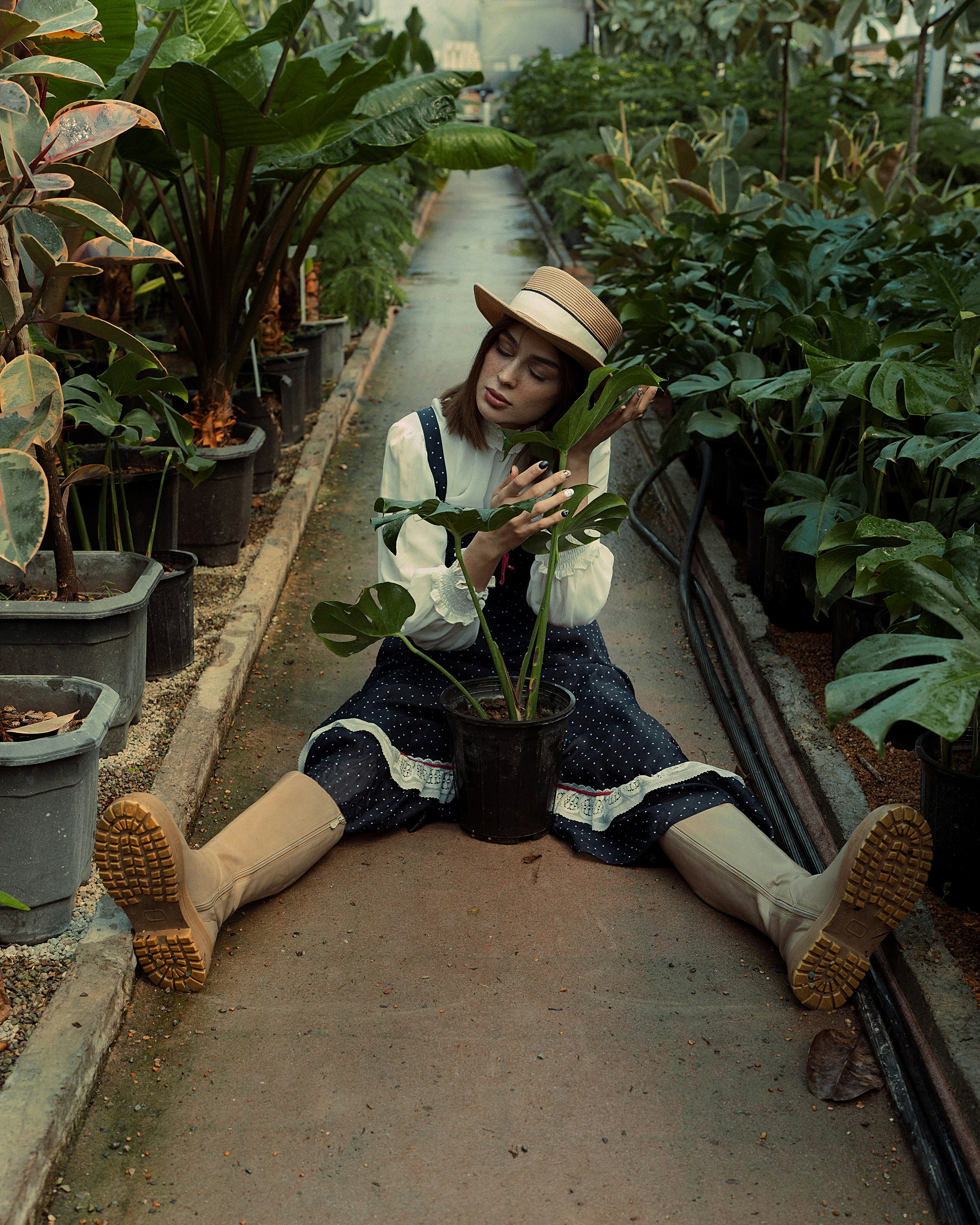 a woman sitting on the ground holding a plant