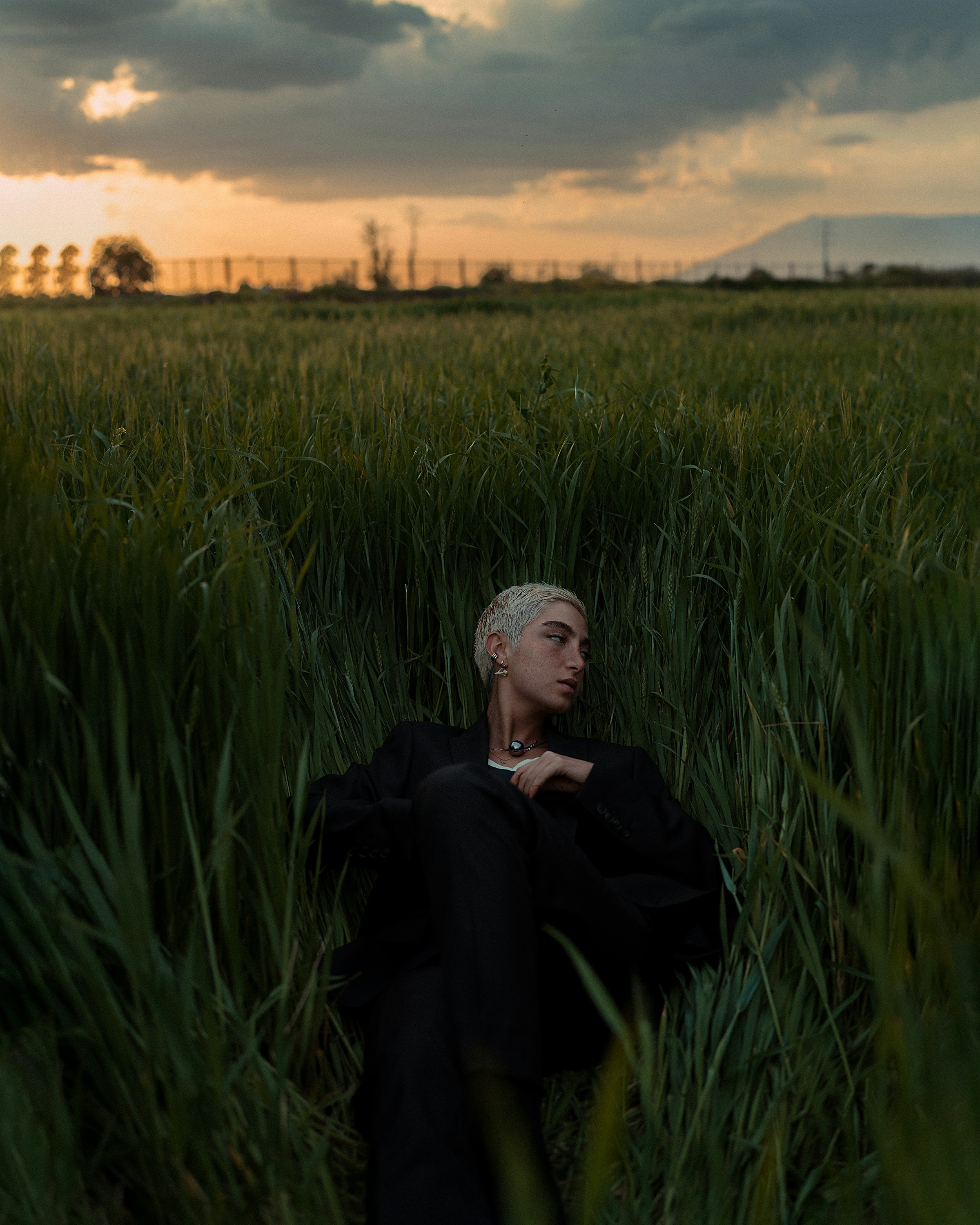 a woman sitting in a field of tall grass