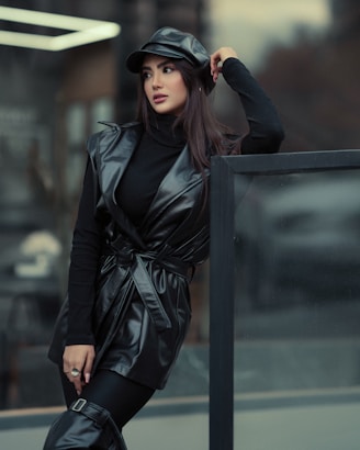 a woman in a black leather outfit and hat