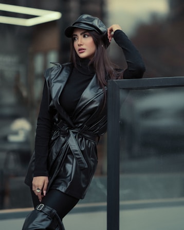 a woman in a black leather outfit and hat