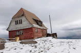 a red house sitting on top of a snow covered hill