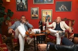 a group of men sitting around a table drinking wine