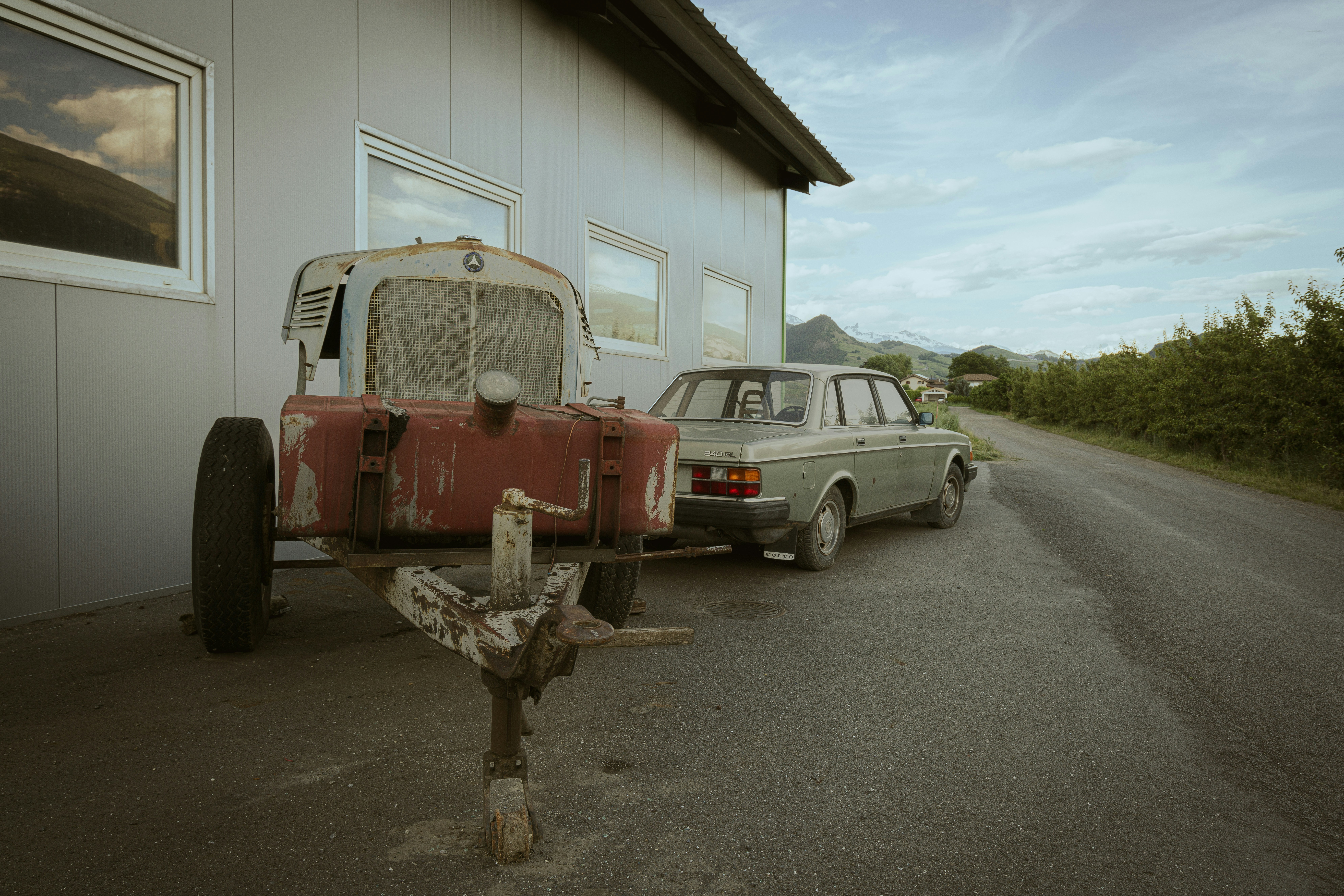 two old cars parked next to a building