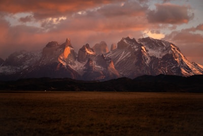 a mountain range with snow capped mountains in the background