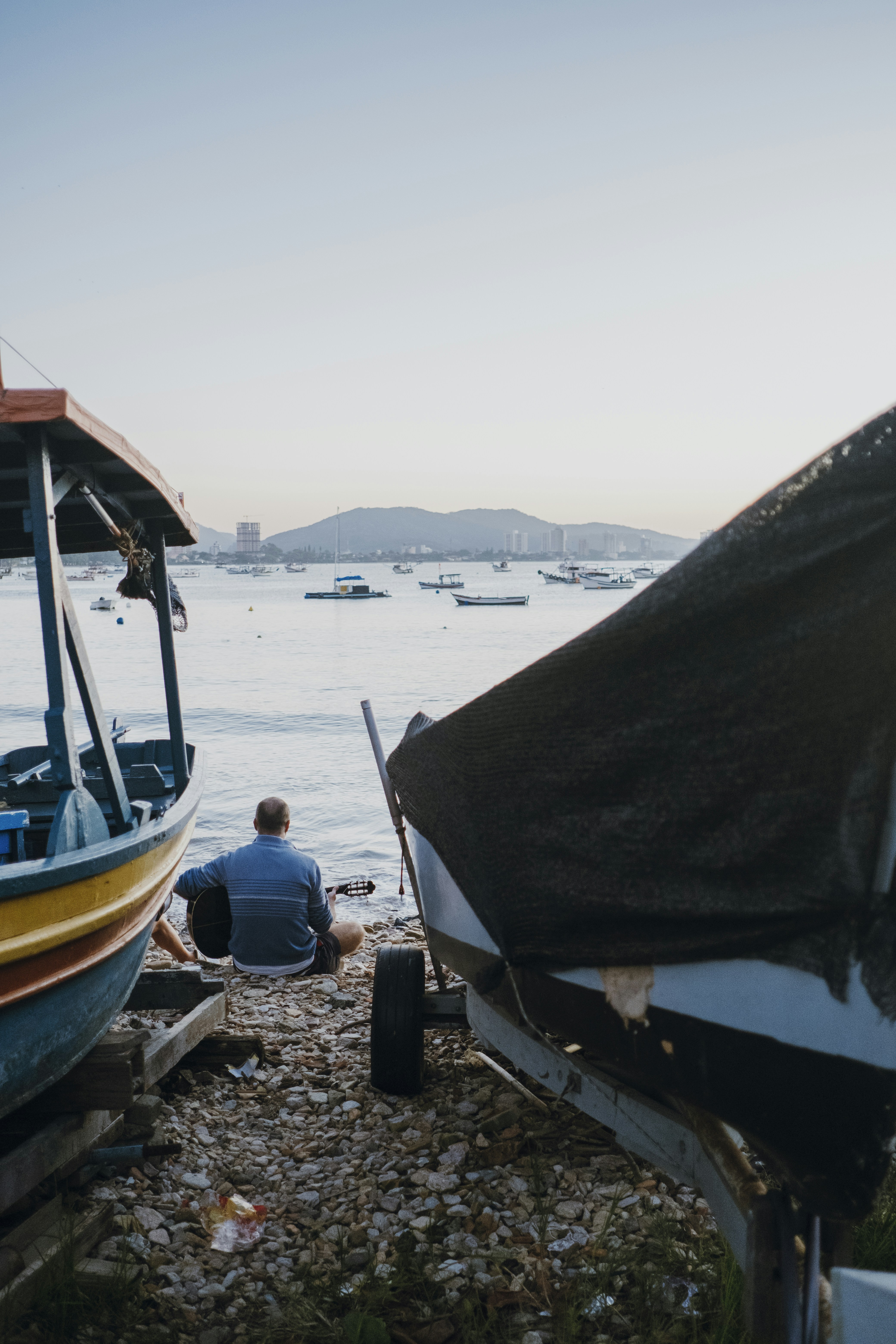 a man sitting on the ground next to a boat