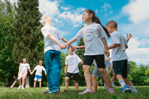 a group of children holding hands in a park