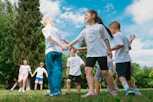 a group of children holding hands in a park