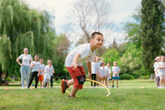 a young boy playing a game of frisbee in a park