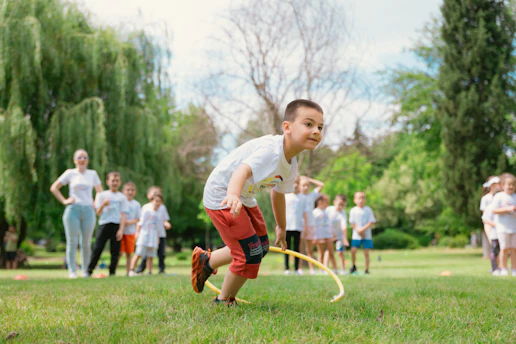 a young boy playing a game of frisbee in a park