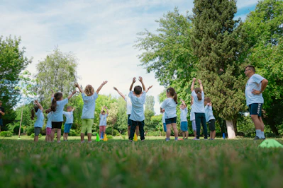 a group of people standing on top of a lush green field