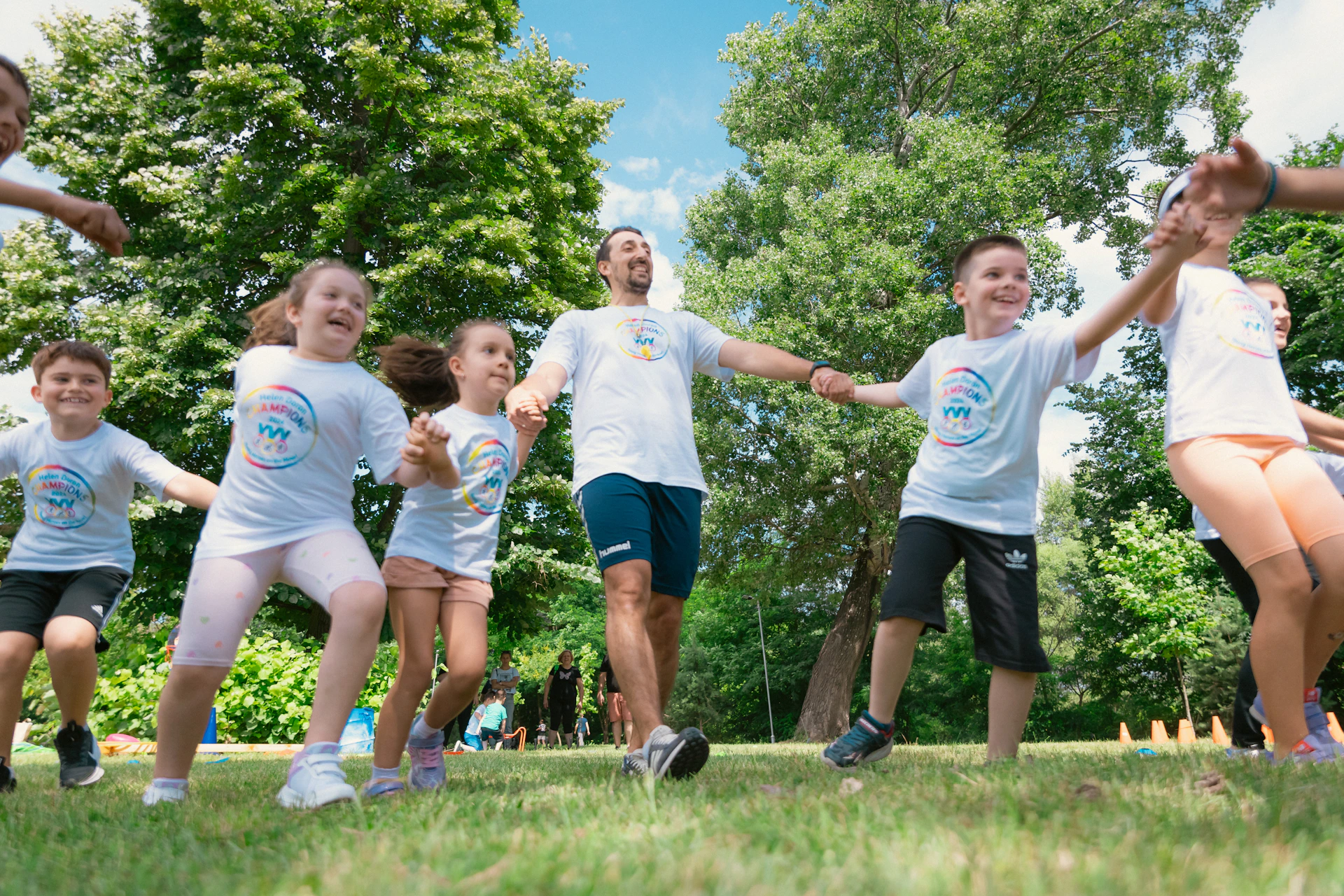 a group of kids are playing tug of war in a park