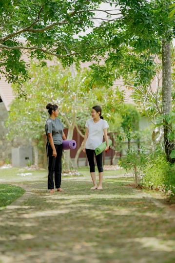 a couple of women standing on top of a lush green field