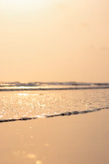 a person walking on a beach with a surfboard