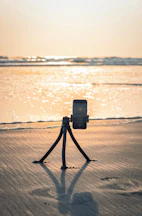 a camera set up on a tripod on a beach