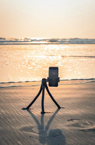 a camera set up on a tripod on a beach