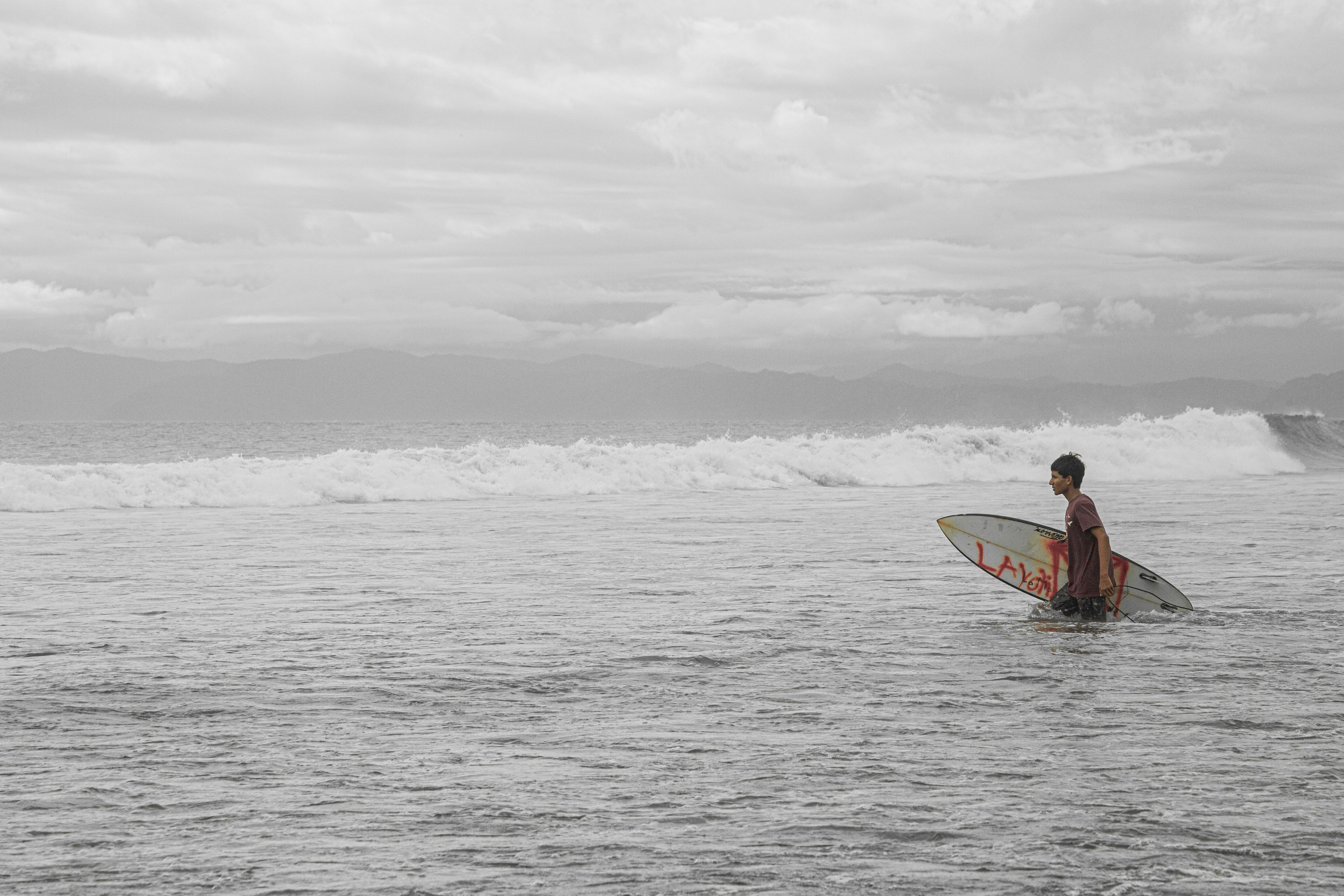 a man holding a surfboard while standing in the ocean