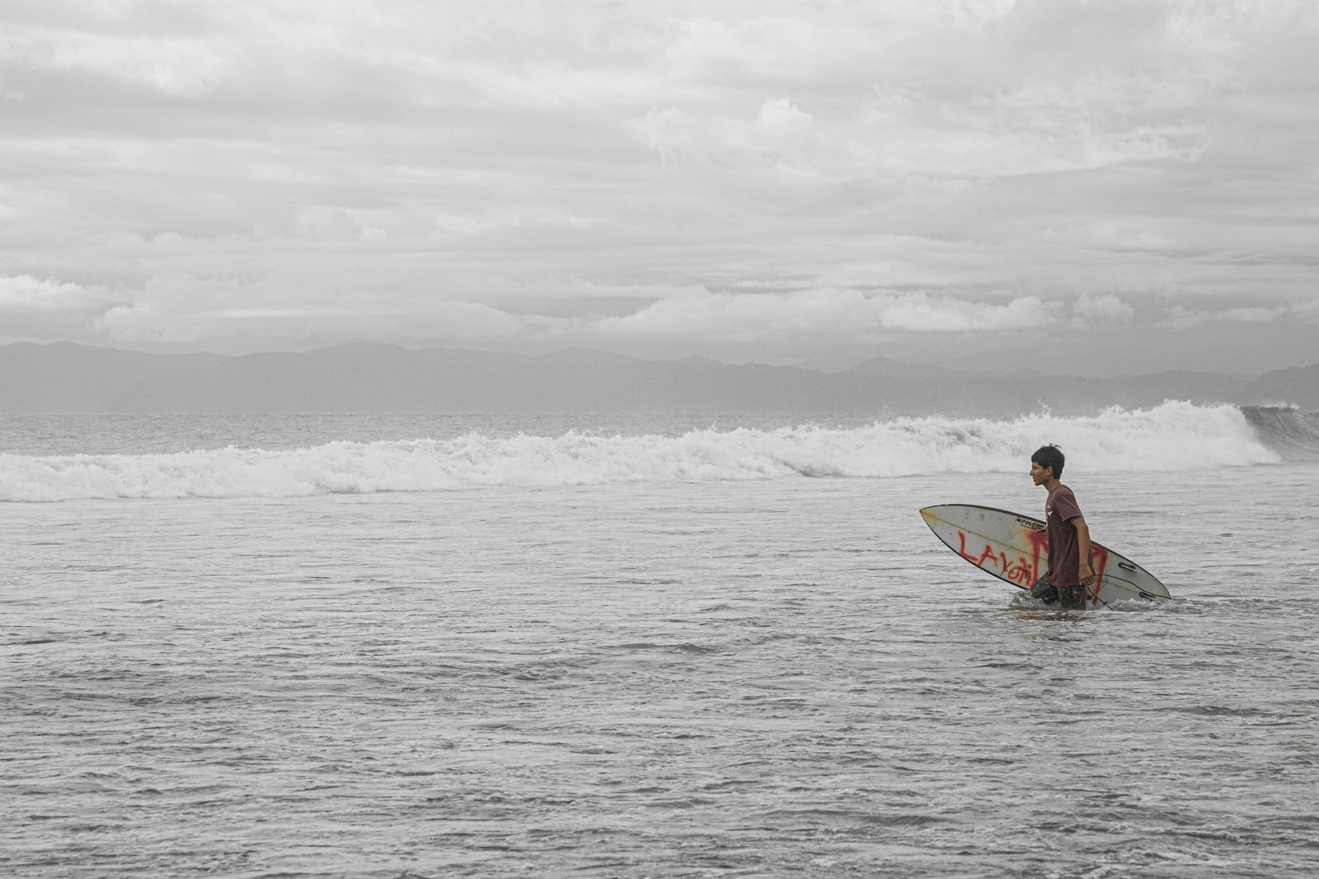 a man holding a surfboard while standing in the ocean