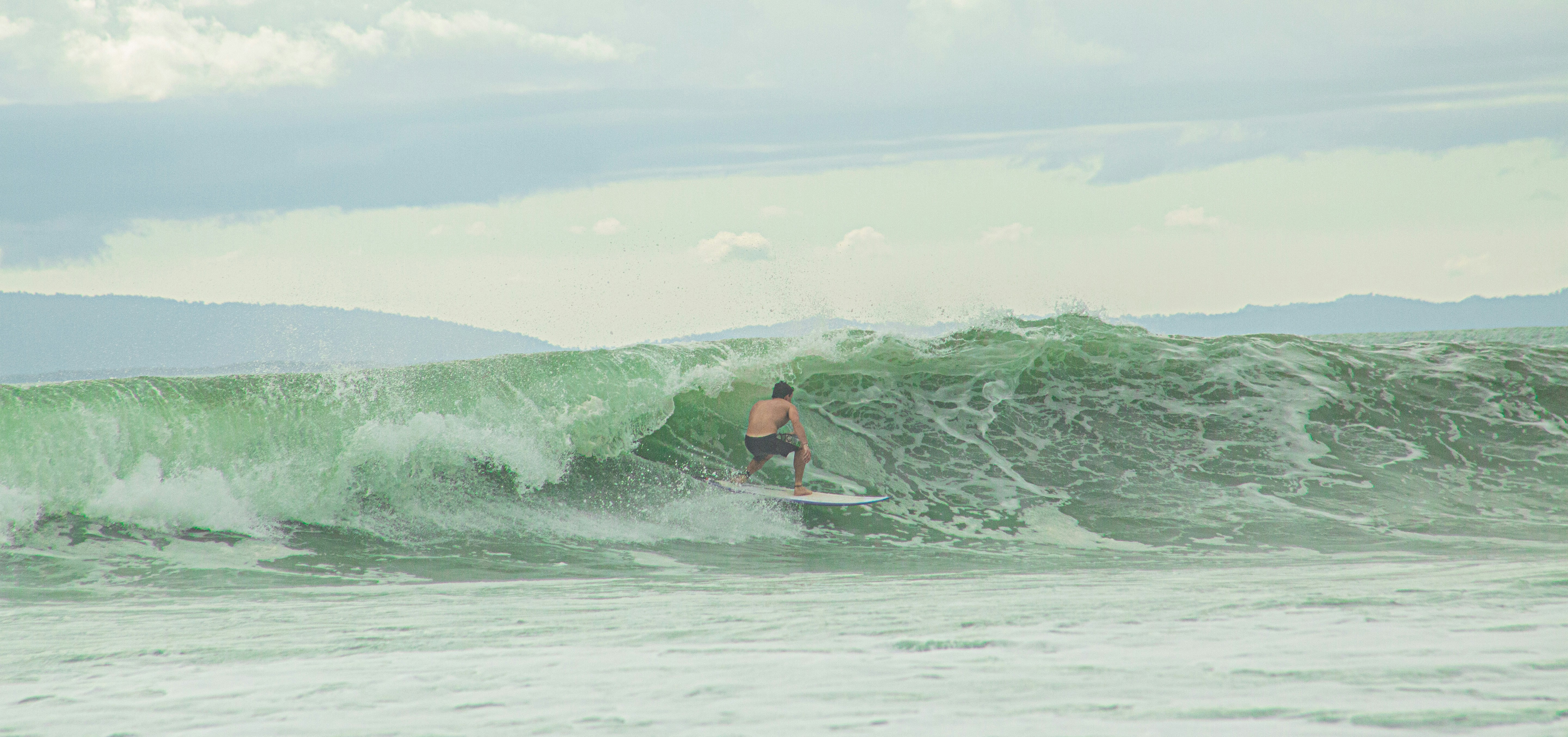 a man riding a wave on top of a surfboard