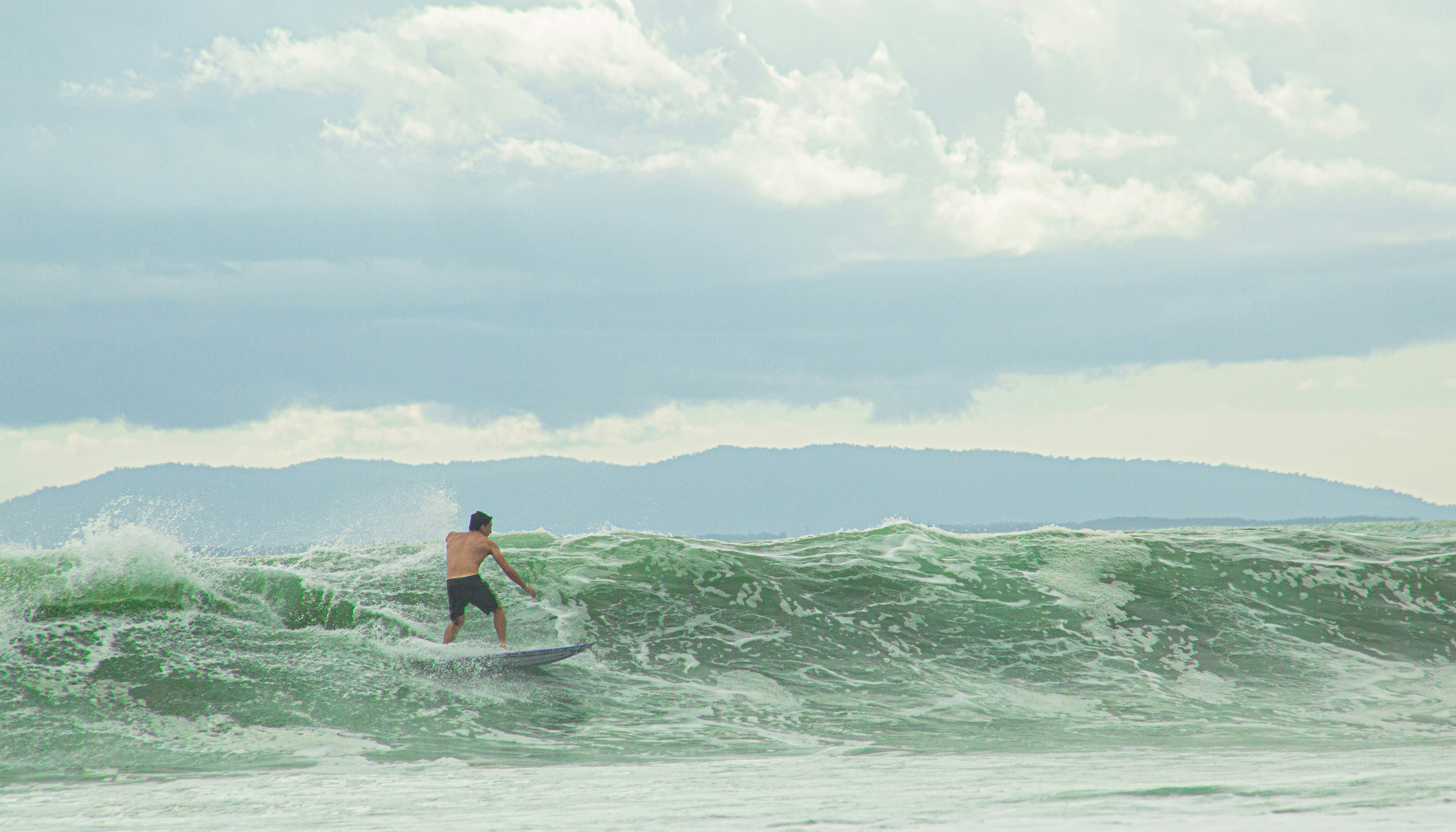 a man riding a wave on top of a surfboard