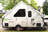 a camper parked in a parking lot next to a tree